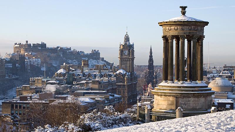 Edinburgh City and Castle viewed from Calton Hill on a beautiful winter morning with the Dugald Stewart monument in the foreground and the castle, Scott monument and Balmoral clock tower in the background.