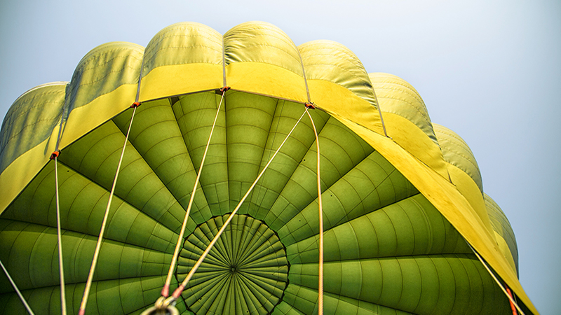 Wallpaper of hot air balloon with ropes hook from the basket in blue sky